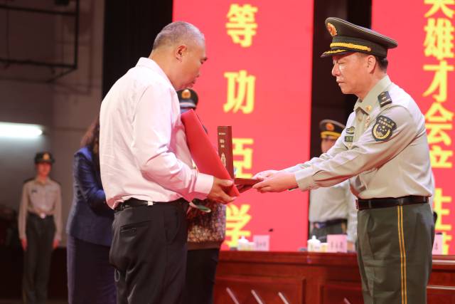 汪曉龍家屬接過一等功獎(jiǎng)?wù)录蔼?jiǎng)勵(lì)證書